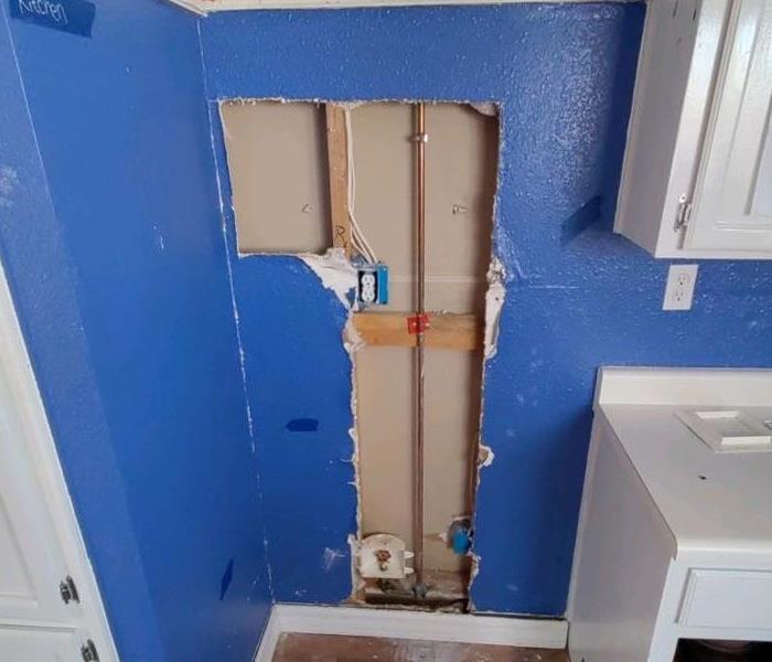 Blue wall partially removed after water damage in home