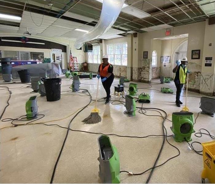 Female SERVPRO employees cleaning up water damage on commercial property