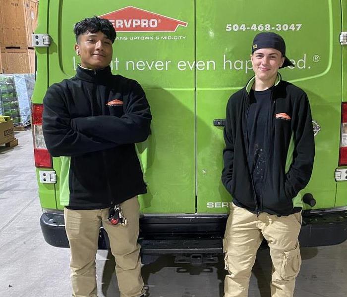 male and female SERVPRO employee standing in front of SERVPRO truck in our Kenner Warehouse